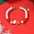 Pulsera navideña de perlas con cuentas rojas y dije de guante sobre fondo festivo - Estilo Guante (SL8980)