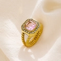 Makroaufnahme eines Goldrings mit rechteckigem rosa Edelstein und geflochtener Ringschiene - US 6 / Gold mit rosa Strasssteinen
