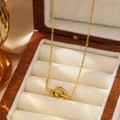 Élégant collier à nœud plaqué or 18 carats présenté dans un écrin à bijoux en bois raffiné - Collier Pendentif Nœud