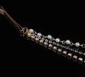 Detalle macro de diadema de borlas multicapa con perlas, cadenas doradas y pedrería brillante - Dorado