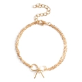 Detail eines goldenen zweilagigen Schleifenarmbands mit Karabinerverschluss und Kette - Gold