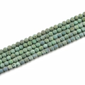 Macro detail of 8mm matte natural stone beads with colorful green and purple textures - 8mm / Grass Green