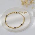 Detailed macro view of 18K gold-plated blade chain with black rectangular zircon stones - Bracelet / Gold + Black Zirconia