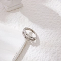 Gros plan d'une bague argentée minimaliste à double couche sur un support d'art blanc - US 6 / Argent