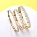 Detailed view of three stackable gold-plated stainless steel bangles with pavé set zircons - 4mm / Gold