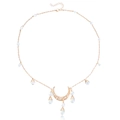 Dettaglio del ciondolo a luna dorata con perle e motivi traforati in stile boho - Oro