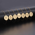 Detailed view of gold circular pendants featuring rhinestone-studded letters R to Z on bracelets - Gold (W)