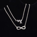 Cavigliera d'argento a strati con cuore, lettera X e simbolo dell'infinito su nero - Stile Lettera X