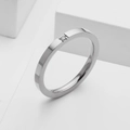 Macro view of minimalist silver stainless steel ring featuring a single inset round diamond - US 5 / Silver