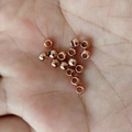 Rose gold stainless steel spherical spacer beads for DIY jewelry making displayed on hand - OD 2mm*ID 1mm / Electroplated Rose Gold