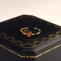 Nahaufnahme eines goldenen Tropfenrings mit rosa Stein auf einer edlen Schmuckschatulle - Rosa Stil (R00027R)