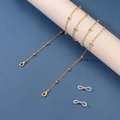 Detailed shot of golden bead chain with lobster clasps and anti-slip silicone loops - 14K Gold