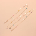 Detail of gold metal eyewear chain featuring colorful heart beads and lightning pendants - Gold