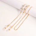 Détail de la chaîne de lunettes dorée avec breloques en cristal sur pilier blanc - Style Décor Strass (5#)