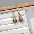 Orecchini a goccia dorati con pietre di zircone blu a forma di pera e chiusura a monachella - Stile Blu