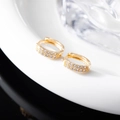 Macro shot of gold-plated hoop earrings with double row of white cubic zirconia stones - Gold