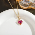 Macro detail of French vintage maple leaf pendant necklace with red gradient crystal - Reddish Brown