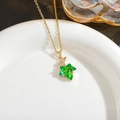 Detailed close-up of green crystal maple leaf pendant on a fine gold-plated chain - Green