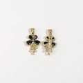 Macro view of gold flower pendant with black pear-shaped gems and tassel details - Black