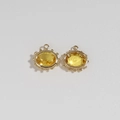 Macro view of gold plated evil eye charms with faceted yellow gemstones and bead details - Yellow