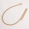 Dettaglio di una catena da corpo dorata a maglia cubana con fibbia e ciondolo a goccia - Oro