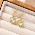 Detail of gold heart pendant earrings with iridescent green crystal in a velvet box - Mocha Green