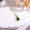 Macro detail of teardrop green gemstone pendant with pavé diamonds on stone base - Malachite green