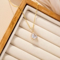Elegant gold-plated waterdrop necklace with shimmering zircon halo on a beige jewelry display - White