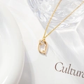 Golden necklace with letter Q pendant featuring a zircon flower charm on white background - Letter Q