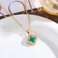 Detailed close-up of a gold clover necklace with green stone and pavé diamond border - Peacock Green