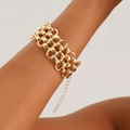 Close-up of a wide punk style chunky gold chain bracelet with lobster clasp on wrist - Bracelet / Gold
