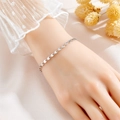 Elegant silver four-leaf clover bracelet for women with radiant texture on a model's wrist - Steel