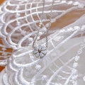 Minimalist daisy pendant necklace in silver finish on white lace embroidery background - Daisy Necklace / 10mm / Silver