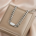 Silver Cuban link necklace featuring a polished oval plaque charm on a silk jewelry box - Silver Oval ID Tag Cuban Necklace (N450)