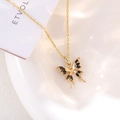 Detail of elegant gold butterfly necklace with black zircon wings in a ceramic bowl - Black