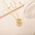 Dettaglio macro di una collana con ciondolo a lettera S dorata con cristalli su pietra - Stile Lettera S (S)