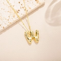 Vista macro del ciondolo lettera W in oro 18K con zirconi cubici su una catena a sfere - Stile Lettera W (W)