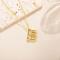 Detailed close-up of a 18K gold plated letter B pendant with sparkling zircon stones - Letter B Style (B)