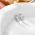 Close-up of S925 silver hoop earrings with pave white cubic zirconia on a white plate - Silver