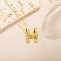 Dettaglio della collana con ciondolo a lettera H dorata 3D e zirconi su base di pietra - Stile Lettera H (H)
