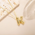 Dettaglio collana dorata con pendente lettera K in zirconi su una catena con perline - Stile Lettera K (K)