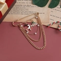 Detail view of gold Christmas safety pin brooch with reindeer charm and NOEL chain - White Elk NOEL Pearl Style (ZW2417)