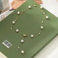 Close-up of golden Y-shaped necklace with pearls on an olive green background - Pearl Tassel Adjustable Style (81294)