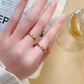 Detailed view of two gold multifaceted geometric rings styled on fingers with props - US Size 5 / Quilted Pattern Gold