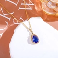 Dettaglio ravvicinato del ciondolo a goccia in zaffiro blu con catenina dorata - Blu medio