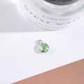 Detail of faceted green crystal pendant with silver bezel set against a minimal background - Outer Size 6.5x10mm / Light Green