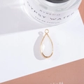Macro shot of gold-plated pear-cut milky white crystal drop pendant on white display - Outer Size 11x25mm / White Jade