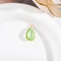Detail van een groene kristallen druppelhanger met vergulde klauwzetting voor sieraden - Lichtgroene Stijl (10)