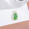 Detailed macro shot of green teardrop crystal pendant with elegant gold plated metal frame - Outer Size 11x25mm / Light Green