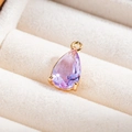 Vue macro d'un pendentif en cristal lavande en forme de goutte et monture dorée - Violet Cristal